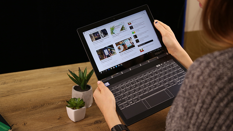 Woman holding laptop on hand