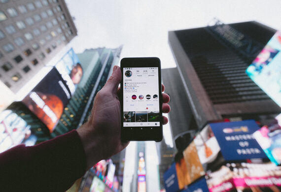 Person holding mobile phone with instagram apps on the screen