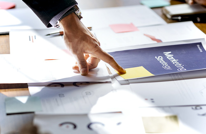 hand of a businessman pointing his finger with the blue book the table