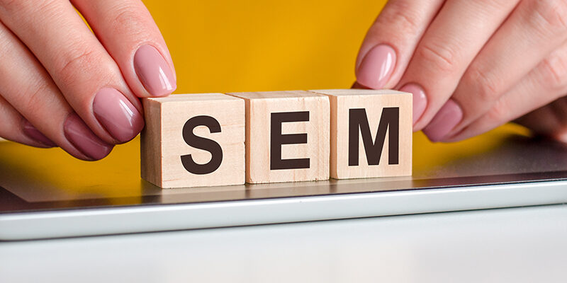 word SEM is written on wooden cubes standing on a notepad