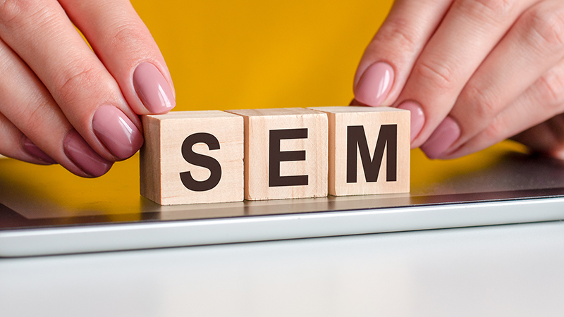 word SEM is written on wooden cubes standing on a notepad
