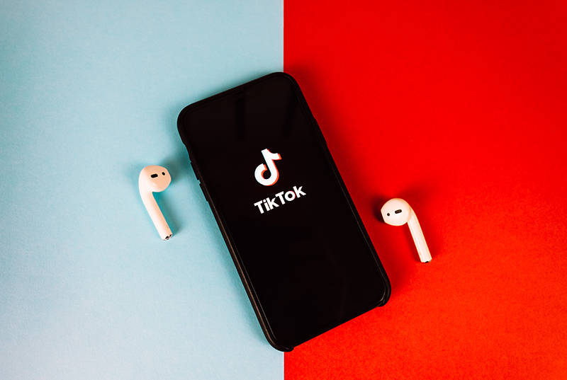 TikTok app logo on the screen. red-blue background