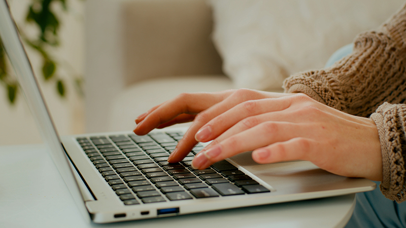 Female hands typing on laptop keyboard