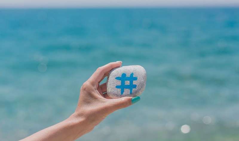 woman holding a stone with hashtag icon
