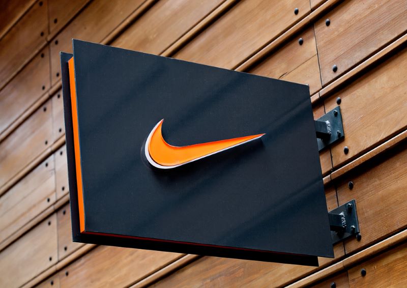 Nike logo on black display plate on wooden background