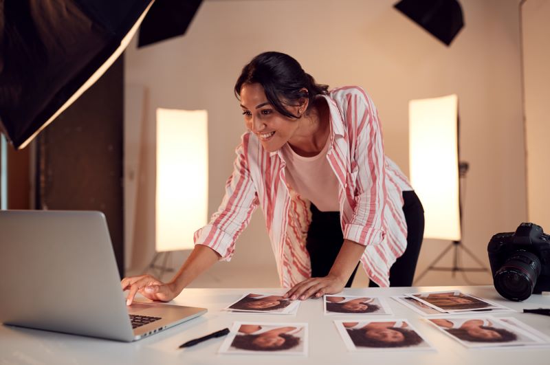 Female Photographer Editing Images From Photo Shoot In Studio