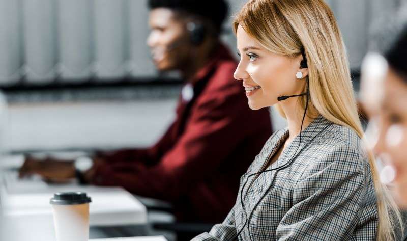 selective focus of smiling call center operator working in office