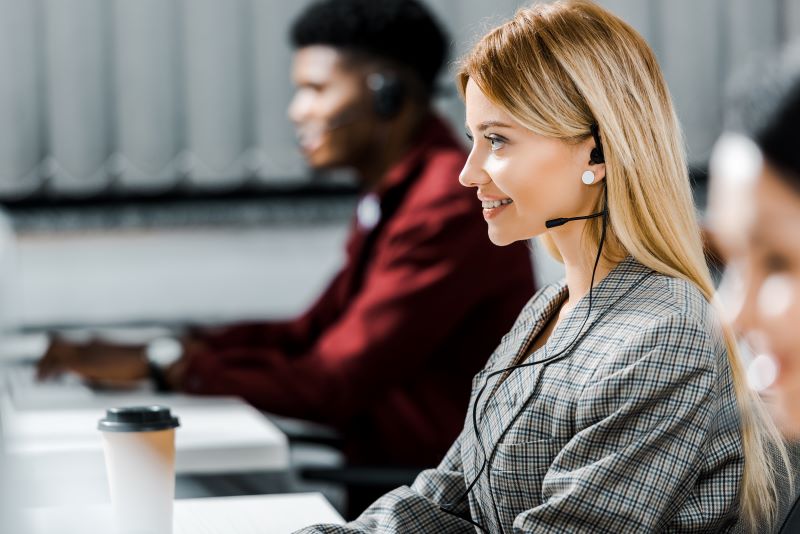 selective focus of smiling call center operator working in office