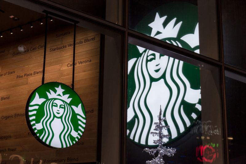 Starbucks logo on a window with a larger logo on the inside of the store